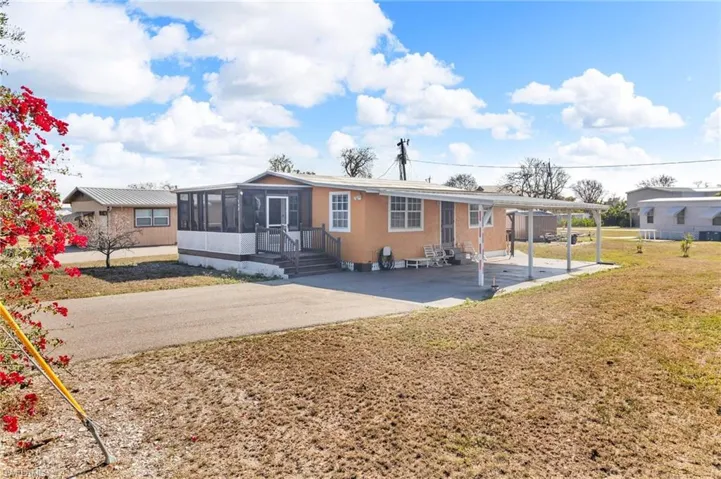 View of front of home featuring entry steps, driveway, a screened in patio, and a front yard