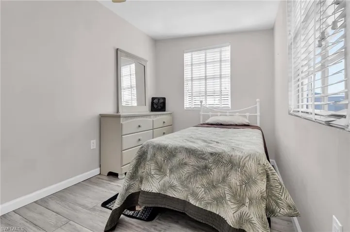 Bedroom featuring light baseboards, and multiple windows