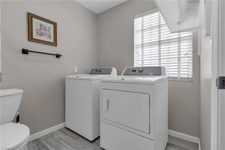 Laundry area featuring washing machine and clothes dryer, laundry area, and baseboards