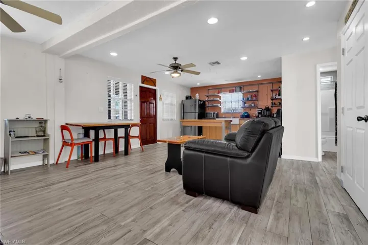 Living area with ceiling fan, light flooring, and recessed lighting