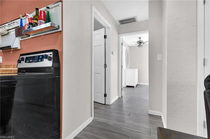Hallway featuring baseboards, and visible vents
