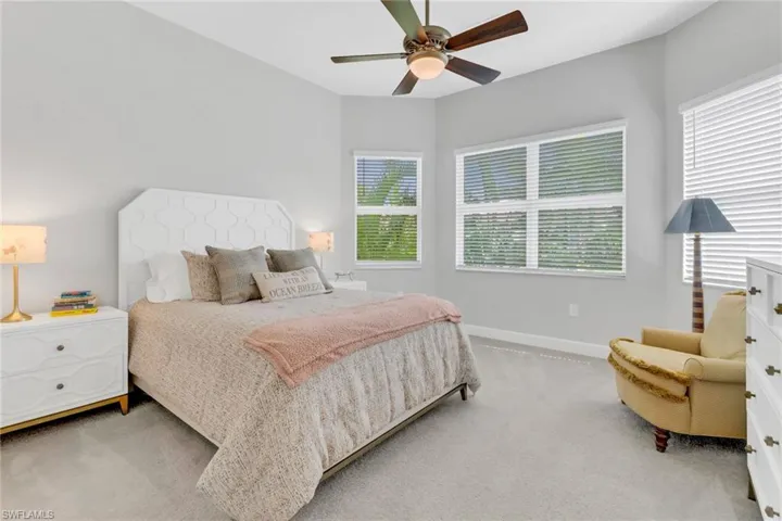 Bedroom with multiple windows, carpet, and ceiling fan