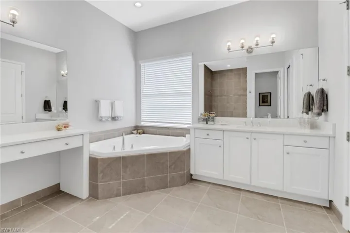Bathroom with vanity, separate shower and tub, and tile patterned flooring