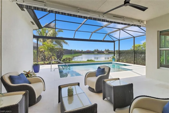 View of swimming pool featuring a patio, a lanai, a water view, and ceiling fan