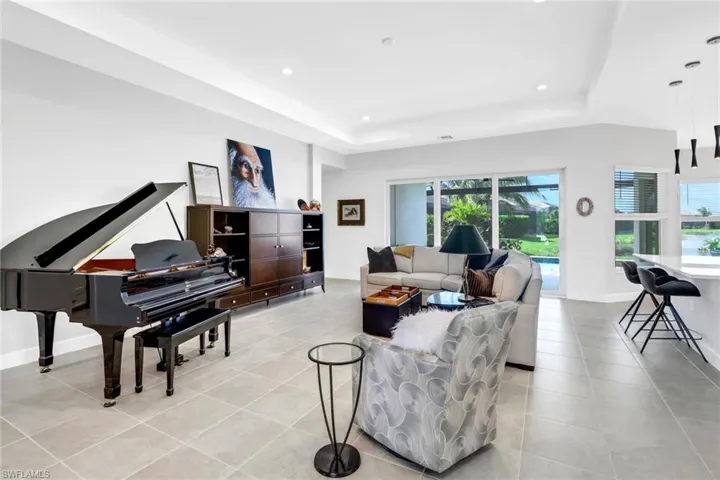 Tiled living room featuring a healthy amount of sunlight and a raised ceiling