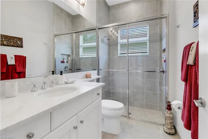 Bathroom featuring toilet, an enclosed shower, vanity, and tile patterned floors