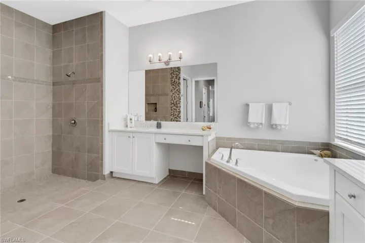 Bathroom featuring vanity, independent shower and bath, and tile patterned floors