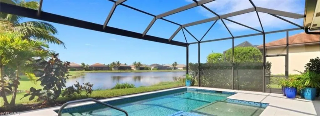 View of pool with a lanai and a water view
