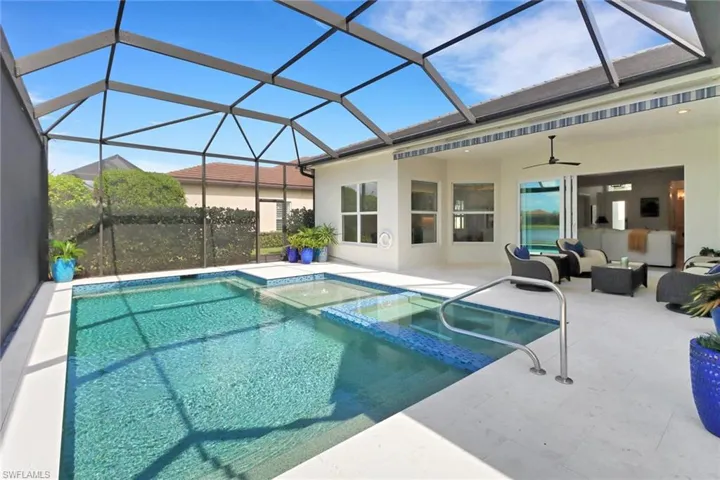 View of pool with an in ground hot tub, ceiling fan, a patio area, and a lanai