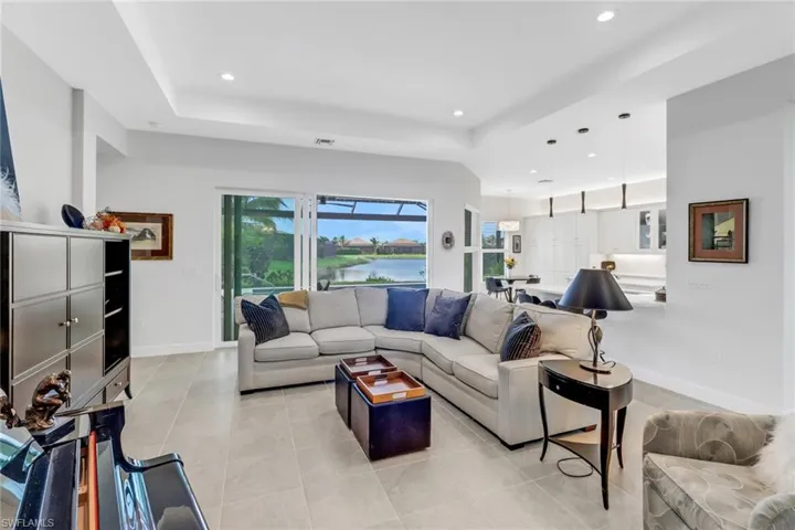 Tiled living room with a water view and a raised ceiling