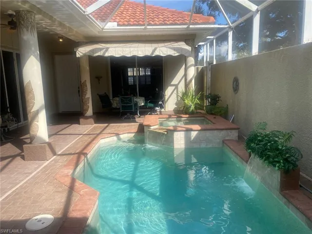 Relaxing pool and spa looking toward seating area and main house entry