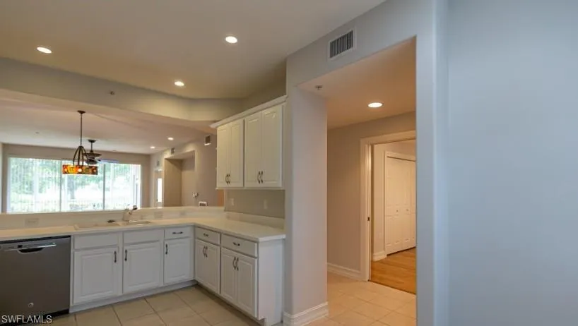 Kitchen featuring a sink, dishwasher, recessed lighting, and white cabinetry