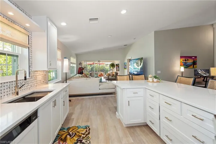 Open kitchen to family, dining, living, area, and sliders to a screened in covered patio with extended lanai