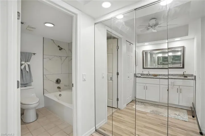 Bathroom featuring double vanity, ceiling fan, shower / bath combination, and recessed lighting