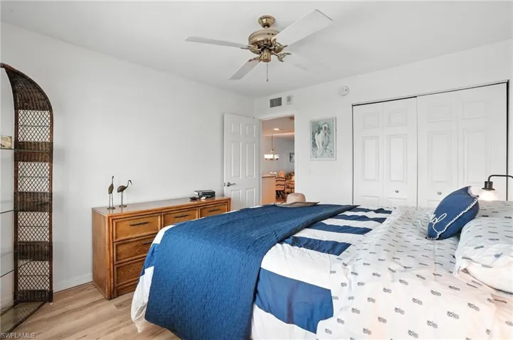 Bedroom featuring light wood finished floors, a closet, and ceiling fan