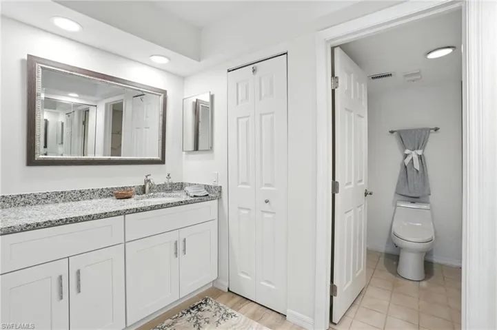 Bathroom with vanity, a closet, and recessed lighting