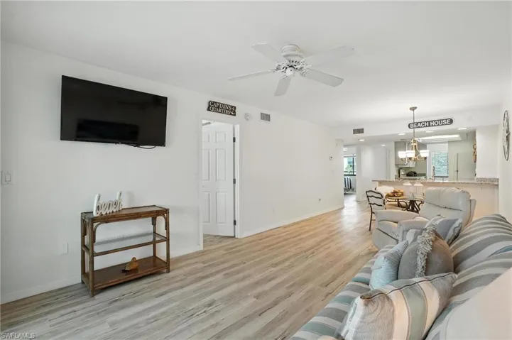 Living area featuring light wood-style flooring, ceiling fan, and recessed lighting