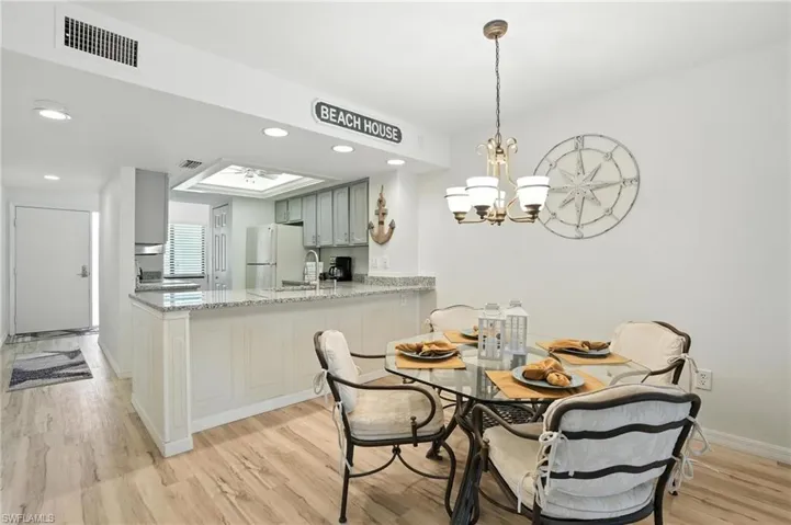 Dining space featuring light wood-type flooring, a chandelier, and recessed lighting
