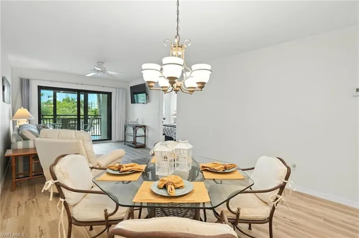 Dining room with a chandelier, light wood-type flooring, and ceiling fan