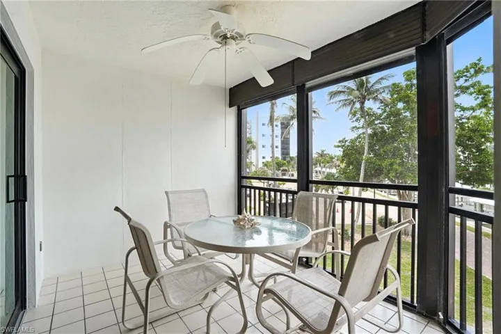 Sunroom / solarium featuring a ceiling fan, tile patterned flooring, and plenty of natural light