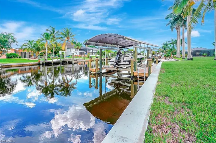View of dock featuring a yard and a water view
