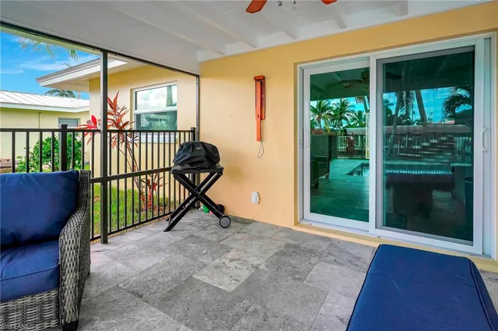 Sunroom with ceiling fan and beam ceiling