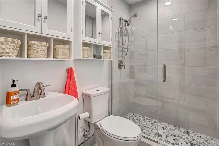 Bathroom with sink, toilet, and walk in shower