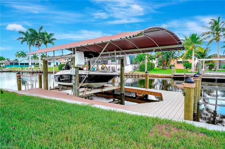 View of dock with a water view and a lawn