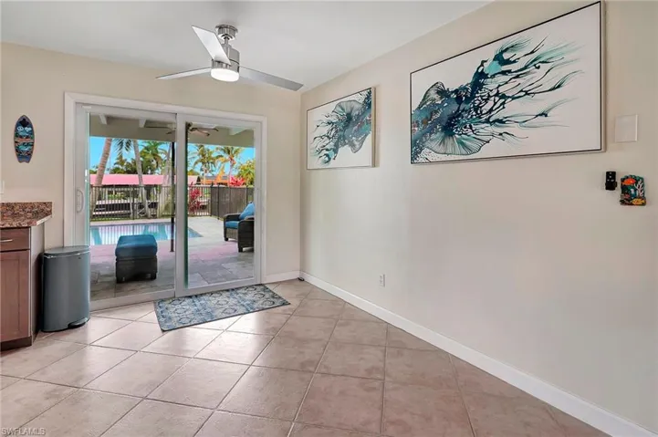 Doorway to outside with light tile patterned flooring and ceiling fan