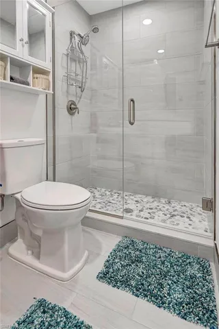 Bathroom featuring toilet, tile patterned floors, and walk in shower