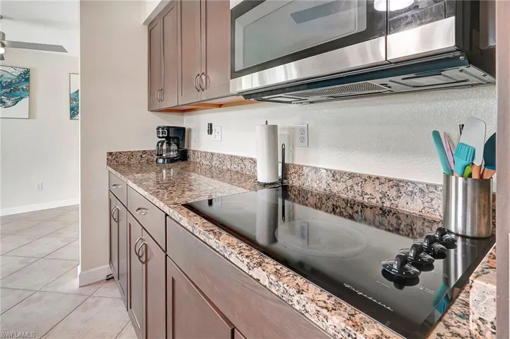 Kitchen with light stone countertops and light tile patterned floors