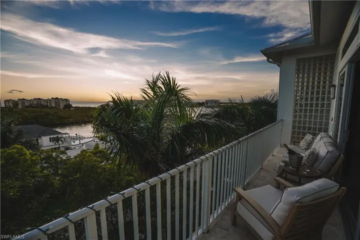 Balcony at dusk featuring a water view