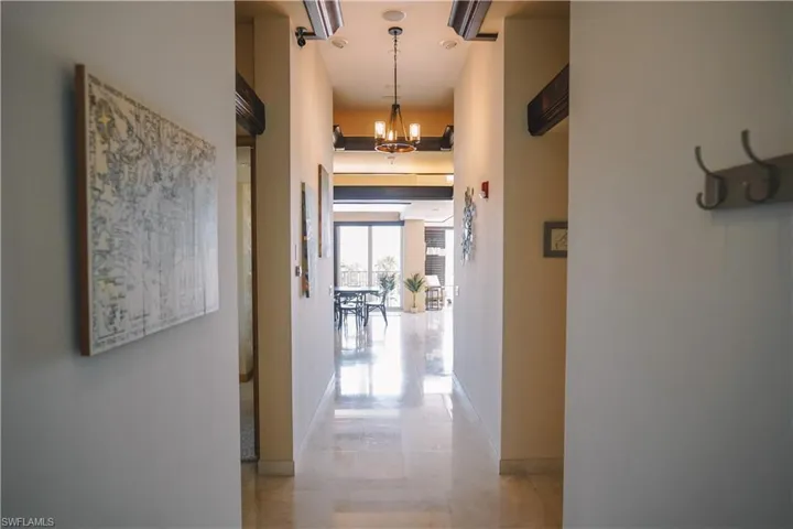Corridor featuring an inviting chandelier