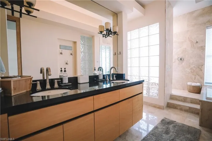 Bathroom with vanity, a chandelier, tile patterned floors, and a wealth of natural light