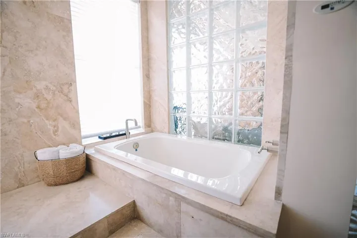 Bathroom with plenty of natural light and tiled bath