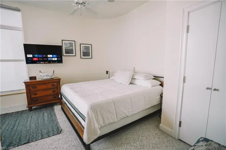 Bedroom featuring ceiling fan, light colored carpet, and a closet