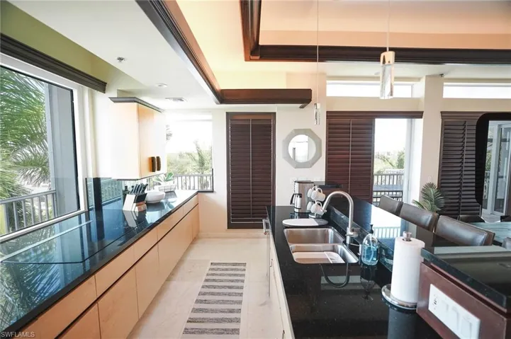 Kitchen featuring sink, light tile patterned floors, and decorative light fixtures