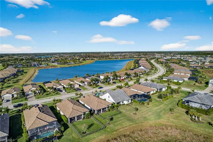 Aerial view of property and surrounding area with a large body of water and nearby suburban area