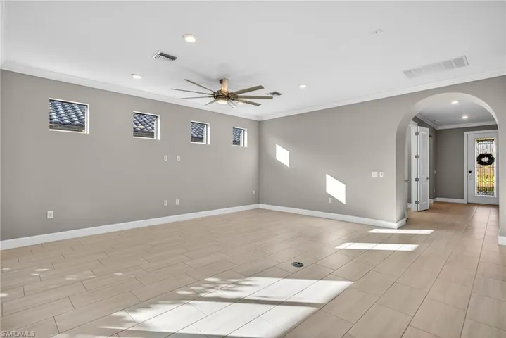 Living room featuring arched walkways, recessed lighting, a ceiling fan, and crown molding