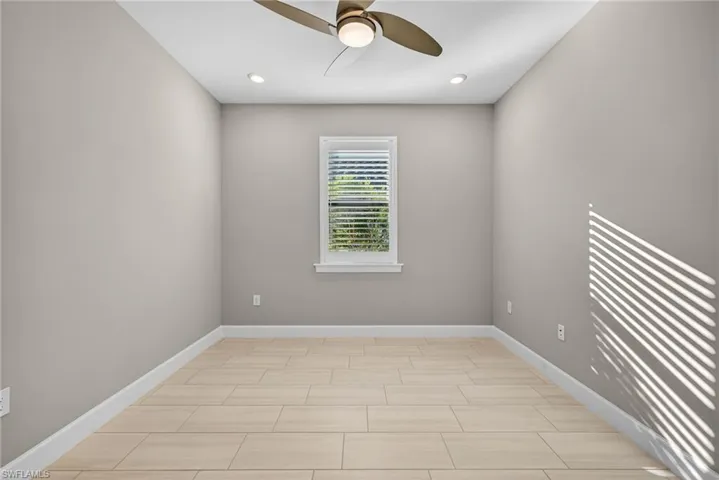 Den with a ceiling fan and recessed lighting