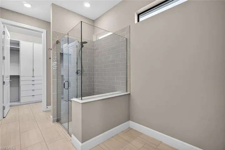 Bathroom with a stall shower and a spacious closet