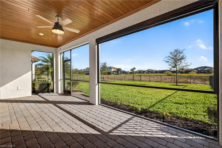 Unfurnished sunroom with a ceiling fan and a residential view
