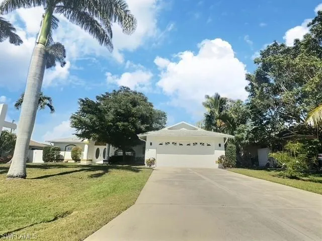 Ranch-style home with an attached garage, driveway, and a front lawn