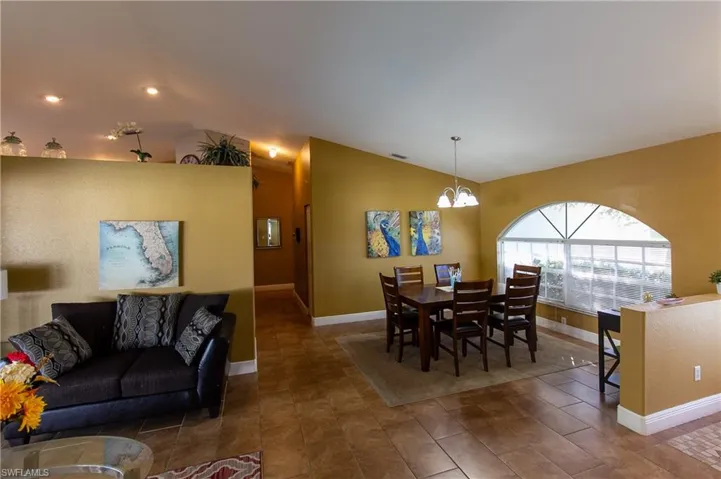 Dining room featuring vaulted ceiling and a notable chandelier