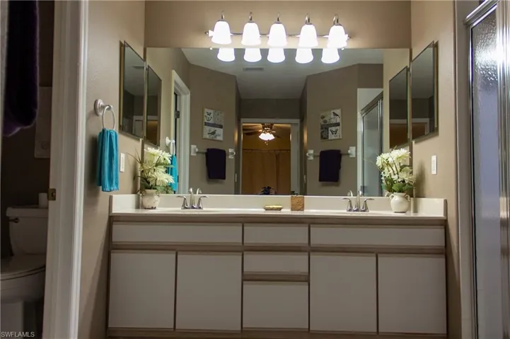 Bathroom featuring vanity, toilet, walk in shower