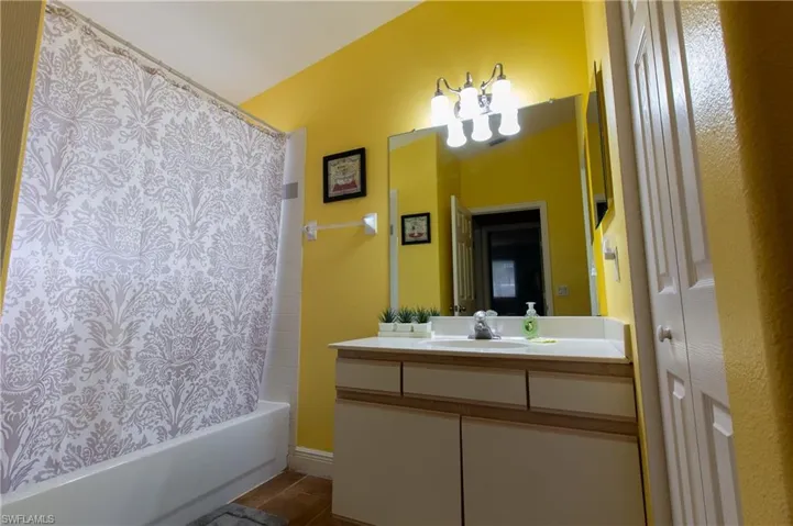 Bathroom with vanity, tile patterned floors, and shower / tub combo