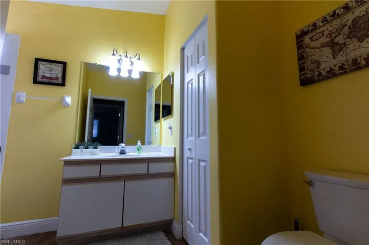 Bathroom with toilet, vanity, and tile patterned floors