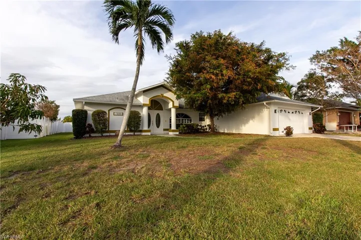 Single story home featuring a front yard and a garage