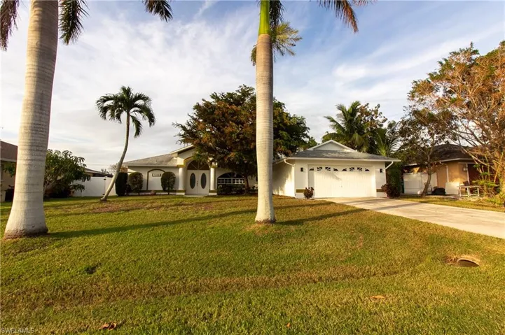 View of front of house featuring a front lawn and a garage
