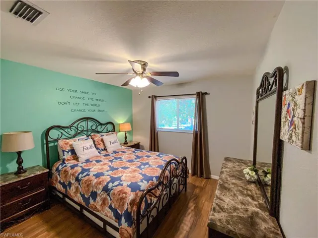 Bedroom featuring ceiling fan, a textured ceiling, and dark hardwood / wood-style flooring